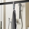 Gray towel hanging on a rack with text about a button loop for easy hanging, quick drying, ease of care, and machine washability.