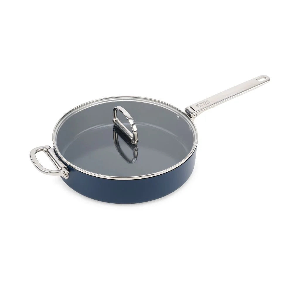 Blue Joseph Joseph ceramic non-stick 28cm sauté pan with folding handle and lid on a wooden countertop.