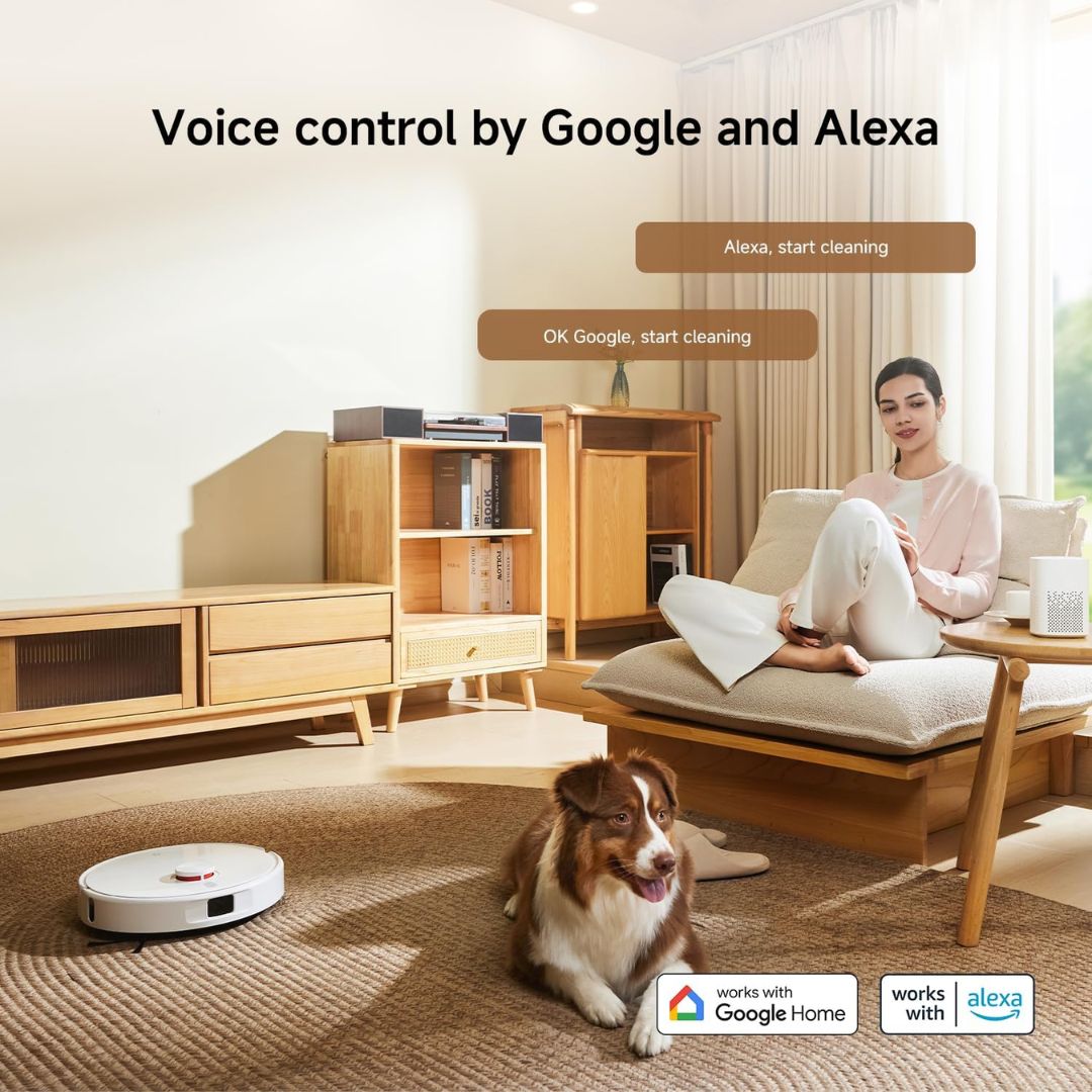 A white robotic vacuum cleaner is shown in a modern living room with a woman sitting on a chaise and a dog lying on the rug, with text reading 'Voice control by Google and Alexa' and compatibility logos at the bottom.