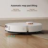 A white robotic floor cleaner is shown on a wood floor and carpet, with text above reading 'Automatic mop pad lifting' and small blue arrows indicating lifting action. No person or animal is present, but this is not a clean isolated studio product shot because it includes a real indoor environment and explanatory overlay, so Lifestyle fits better than Product/Packaging.