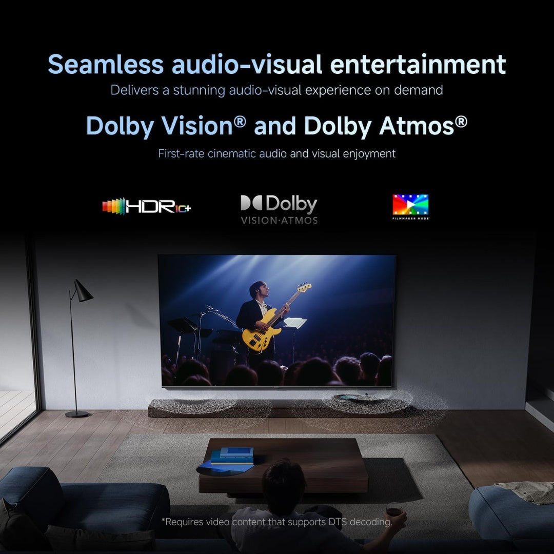 Living room setup with a large TV displaying a concert, featuring Dolby Vision and Atmos logos.